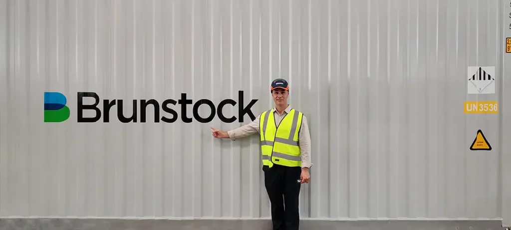 Daniel Tragai, CEO of Kookaburra Power Technologies, standing in front of one of the Monarto BESS energy storage containers at the Brunstock factory.